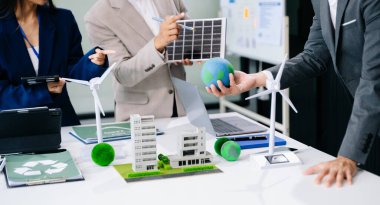 İşletme ekibi, dizüstü bilgisayar ve dijital tablet kullanarak, geri dönüşüm planlama ve tartışması ofis toplantı odasında yeniden kullanım politikası sembolünü azaltır 