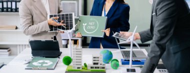 İşletme ekibi, dizüstü bilgisayar ve dijital tablet kullanarak, geri dönüşüm planlama ve tartışması ofis toplantı odasında yeniden kullanım politikası sembolünü azaltır 