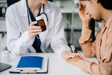 Asyalı kadın hastasına teşhis koyan beyaz kadın doktorun portresi. Muayene odasında hastayla doktor toplantısı.. 