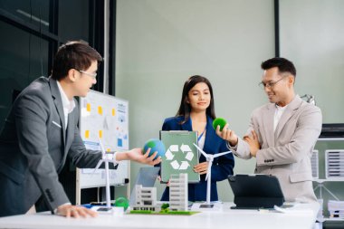 İşletme ekibi, dizüstü bilgisayar ve dijital tablet kullanarak, geri dönüşüm planlama ve tartışması ofis toplantı odasında yeniden kullanım politikası sembolünü azaltır 