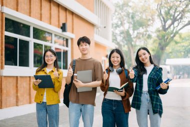 Mutlu Asyalı üniversite öğrencileri kampüs parkında sabahları