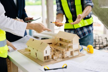 Mimar Asyalı takım inşaat alanında iş arkadaşlarıyla birlikte çalışıyor. Büyük projede mimarlık mühendisliği. İnşaat sürecinde bina içi.