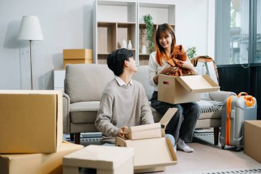 Kutuları olan mutlu Asyalı genç çift yeni bir eve taşınıyor.