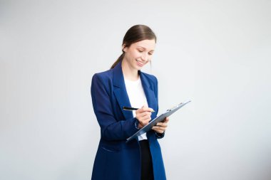 Resmi takım elbiseli beyaz iş kadını beyaz arka planda izole edilmiş belgeleri imzalıyor. 