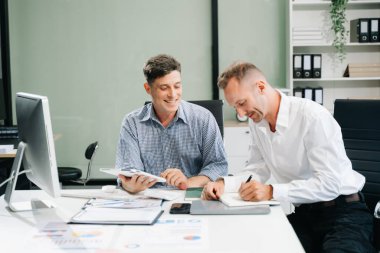 İki iş adamı ofiste iş projelerini tartışıyor.