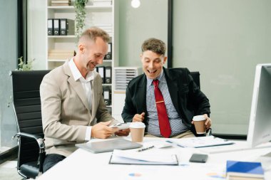 İki iş adamı ofiste iş projelerini tartışıyor.