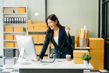 Genç işletme sahibi internetten müşterilere bilgisayar ve el hareketi siparişlerini kontrol ediyor. Çevrimiçi Alışveriş kavramı.