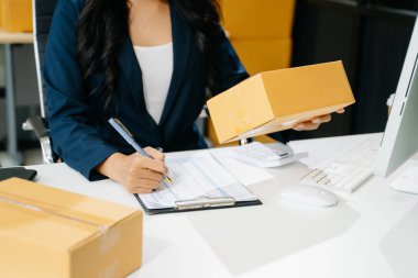 Başlangıçta küçük işletme KOBİ 'si, İş kadını paketin üzerindeki bilgisayar ve adres kullanarak online alışveriş siparişi alır ve kontrol eder