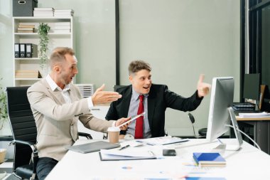 Erkek işçiler modern ofiste yeni projeleri duygusal olarak tartışıyor