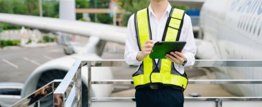 Bir uçak motorunu denetleyen, profesyonellik ve endüstri standartlarını somutlaştıran güvenlik donanımı mühendisi..