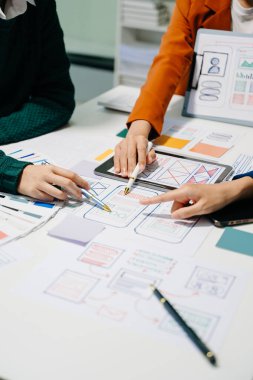  UX geliştiricileri ve ui tasarımcıları modern ofiste müşteri özeti ve renk kodu ile mobil uygulama arayüzü kablo tasarımı hakkında beyin fırtınası yapıyorlar