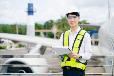 Bir uçak motorunu denetleyen, profesyonellik ve endüstri standartlarını somutlaştıran güvenlik donanımı mühendisi..