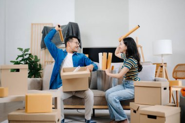 Büyük kutuları olan genç bir çift yeni bir eve taşınıyor ve eğleniyorlar. 