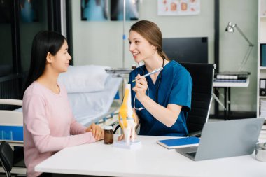 Kadın doktorun portresi hastasına teşhisi açıklıyor. Muayene Odasında Hastayla Doktor Toplantısı. 