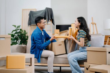 Büyük kutuları olan genç bir çift yeni bir eve taşınıyor ve eğleniyorlar. 
