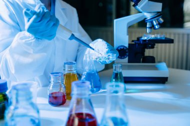 Kimya laboratuvarında kimya sıvılarını karıştıran bilim adamları. Kimya laboratuvarında çalışan bir araştırmacı.