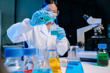 Kimya laboratuvarında kimya sıvılarını karıştıran bilim adamları. Kimya laboratuvarında çalışan bir araştırmacı.