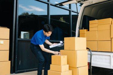 Minibüste paketlerle duran kurye portresi ve panodaki teslimat adresini kontrol ediyorum. Teslimat hizmeti, eve teslimat ve nakliye konsepti