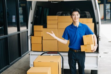 Minibüste paketler ve el hareketleriyle depoda duran kurye portresi. Teslimat hizmeti, eve teslimat ve nakliye konsepti