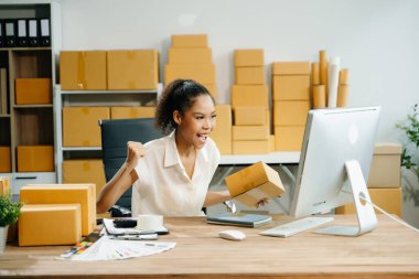 Başlangıçta küçük işletme KOBİ 'si, İş kadını bilgisayar ve el hareketleriyle online alışveriş siparişi alır ve kontrol eder 