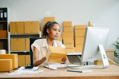 Başlangıçta küçük işletme KOBİ 'si, İş kadını paketin üzerindeki bilgisayar ve adres kullanarak online alışveriş siparişi alır ve kontrol eder