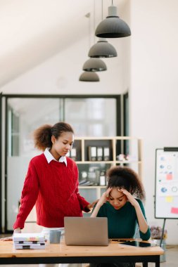 Team thinking of problem solution at modern office. Sad African American businesswomen shocked by bad news, upset in panic after company bankruptcy.  clipart