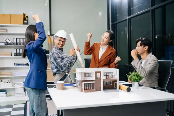 stock image Explore a modern architectural office meeting with asian professionals designing innovative buildings and gesturing hands   