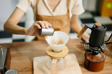 Profesyonel Asyalı barista kafede yüksek kaliteli fasulyelerle taze espresso yapıyor.