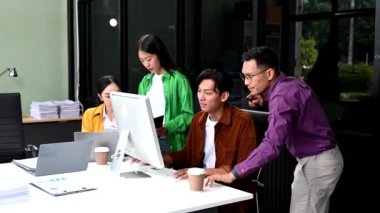 Ofisteki iş arkadaşları konferans odasında bir görüşme yapıyorlar. Yeni başlangıç projesi için bilgisayarlar üzerinde çalışan bir grup iş ekibi