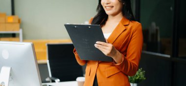 Küçük işletme KOBİ 'si kurun. İş kadını panoya not tutuyor ve çevrimiçi alışveriş sırasını kontrol ediyor.