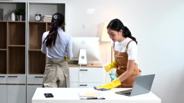 İki Asyalı kadın temizlikçi verimli ve profesyonel temizlik yapıyor. Mükemmel takım çalışması her evde lekesiz temizlik sağlar.. 