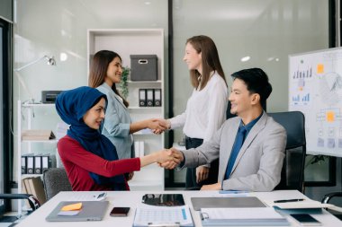 Takım çalışması konsepti, bir grup iş arkadaşının ofiste yaptıkları toplantıda el ele tutuşması.