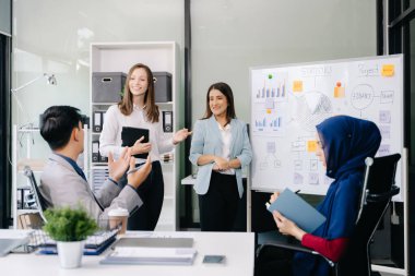 Ofiste yeni bir proje üzerinde çalışırken mutlu iş adamları. Ofiste bir dizüstü bilgisayar ve tablet kullanan bir grup iş adamı