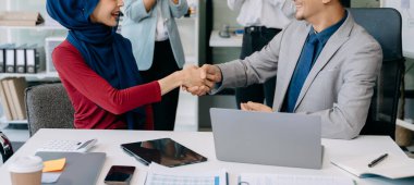 Takım çalışması konsepti, bir grup iş arkadaşının ofiste yaptıkları toplantıda el ele tutuşması.