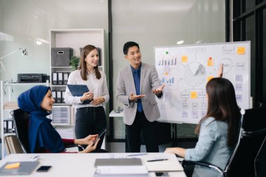 Ofiste yeni bir proje üzerinde çalışırken mutlu iş adamları. Muhtelif iş adamları görev başında.