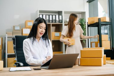 Küçük işletmeler kuran KOBİ sahipleri çevrimiçi siparişleri kontrol ediyor ve ev bilgisayarlarında çalışan ürünleri satıyorlar 