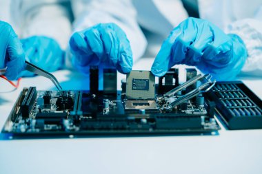 Teknisyenlerin orta bölümü işlemciyi ana bilgisayarın prizine yerleştiriyor. Elektronik mühendislik, elektronik tamir, elektronik ölçüm ve testler, tamir konsepti. 