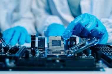Teknisyenlerin orta bölümü işlemciyi ana bilgisayarın prizine yerleştiriyor. Elektronik mühendislik, elektronik tamir, elektronik ölçüm ve testler, tamir konsepti. 