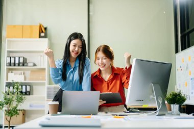 Genç Asyalı iş kadınları işyerindeki başarılarını kutluyorlar