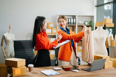 İki profesyonel genç Asya 'lı neşeli kadın moda tasarımcısı bluz için son tasarımı tartıştı. 