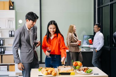 İş arkadaşlarıyla canlı bir ofis partisi. Kutlama, pizza ve içeceklerin keyfini çıkarmak, takım ruhunu ve işbirliği konseptini teşvik etmek..