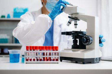 Kadın bilim adamı mikro pipetlerle çalışıyor biyokimyasal örnekleri analiz ediyor, tıp için ileri bilim kimya laboratuvarı.