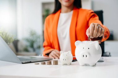 Kadın eli domuz kumbarasına bozuk para sokuyor. iş finans tasarrufu ve yatırım kavramı