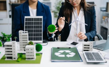 Geri dönüşüm planlayan ve tartışan iş adamları ofis toplantı odasında yeniden kullanım politikası sembolünü azalttı. Yeşil iş şirketi ve Güneş Enerjisi Çevre Kenti Kavramı.