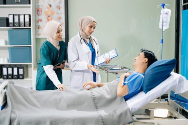 Hastane koğuşunda hasta olan kadın doktorlar profesyonellik ve takım çalışması sergiliyorlar.