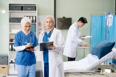 Doktorlar ve hemşireler hastane koğuşunda birlikte çalışıyorlar, profesyonellik ve takım çalışması sergiliyorlar.