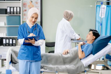 Hastane koğuşunda hasta olan kadın doktorlar profesyonellik ve takım çalışması sergiliyorlar.