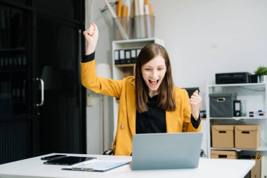 İş kadınlarının elleri dizüstü bilgisayarı modern ofiste çalışmak ve el hareketi yapmak için kullanıyor.
