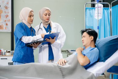 Hastanenin koğuşunda acı çeken kadın doktorlar profesyonellik ve takım çalışması sergiliyorlar.