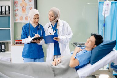 Hastanenin koğuşunda acı çeken kadın doktorlar profesyonellik ve takım çalışması sergiliyorlar.